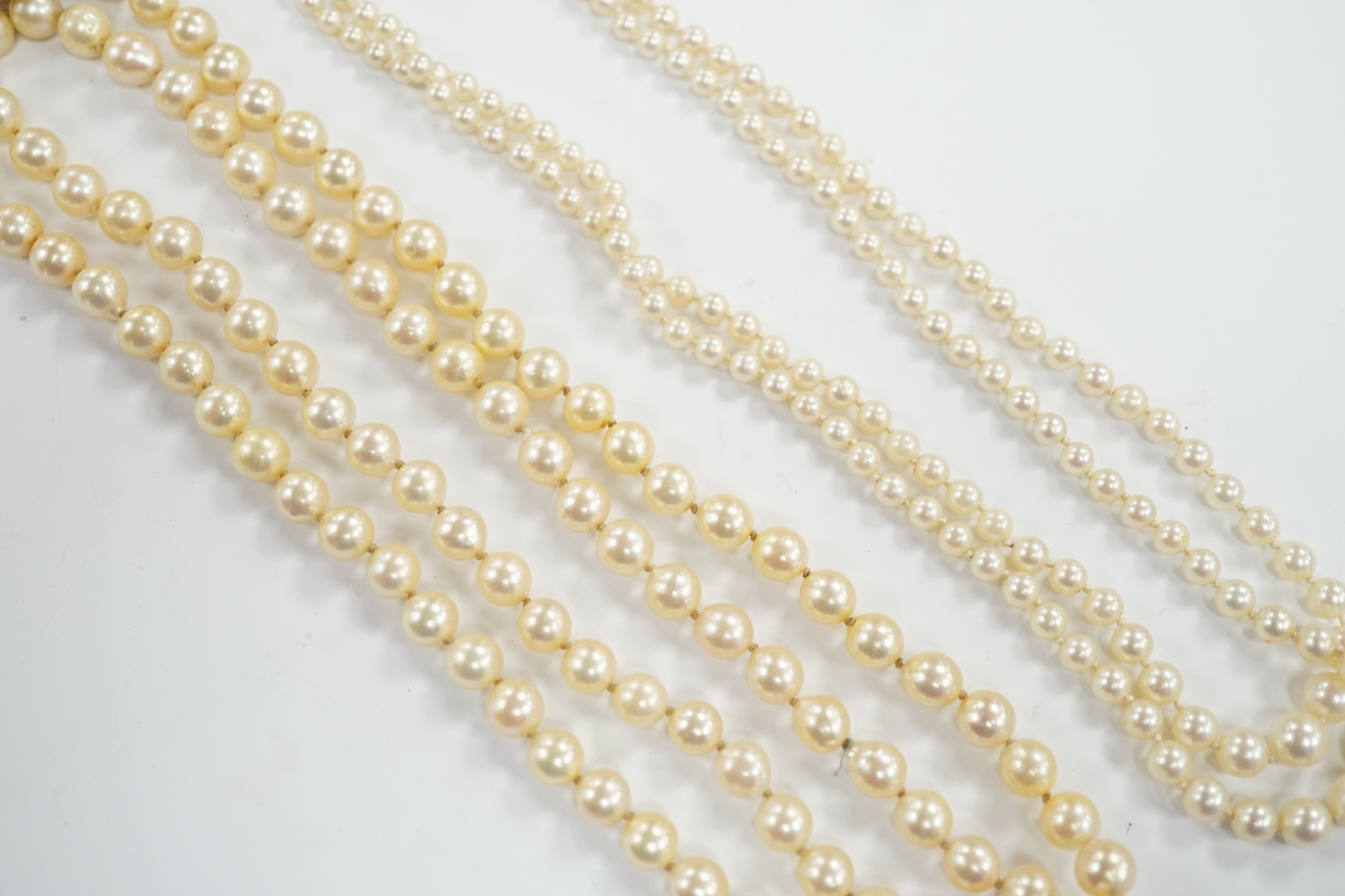 A single strand cultured pearl necklace, with turquoise? and seed pearl set 9ct clasp, 56cm and a double strand cultured pearl necklace with paste set clasp.